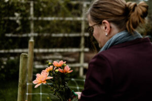 Mevrouw kijkt naar de versgeplukte dahlia's