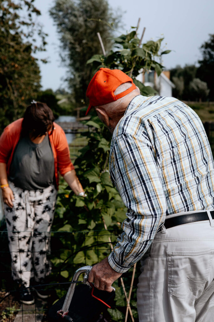 Bezoeker van de zorgboerderij kijkt naar de moestuin