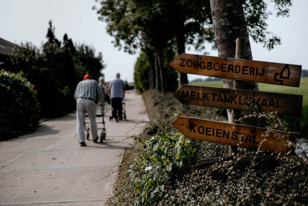 Wegwijzers wijzen de weg naar de verschillende onderdelen van de zorgboerderij, zoals de koeienstal